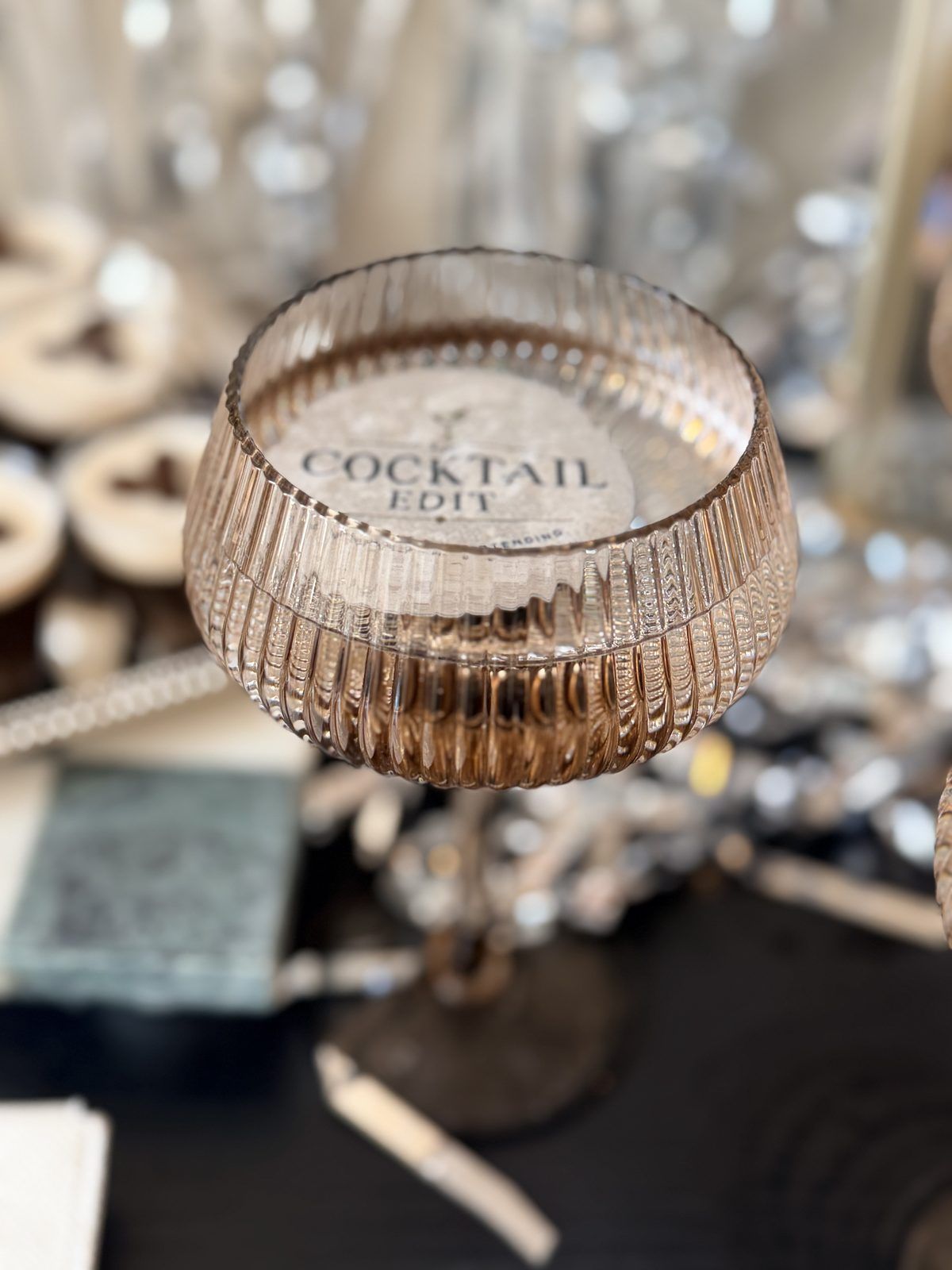 A ribbed coupe on a The Cocktail Edit coaster, close up
