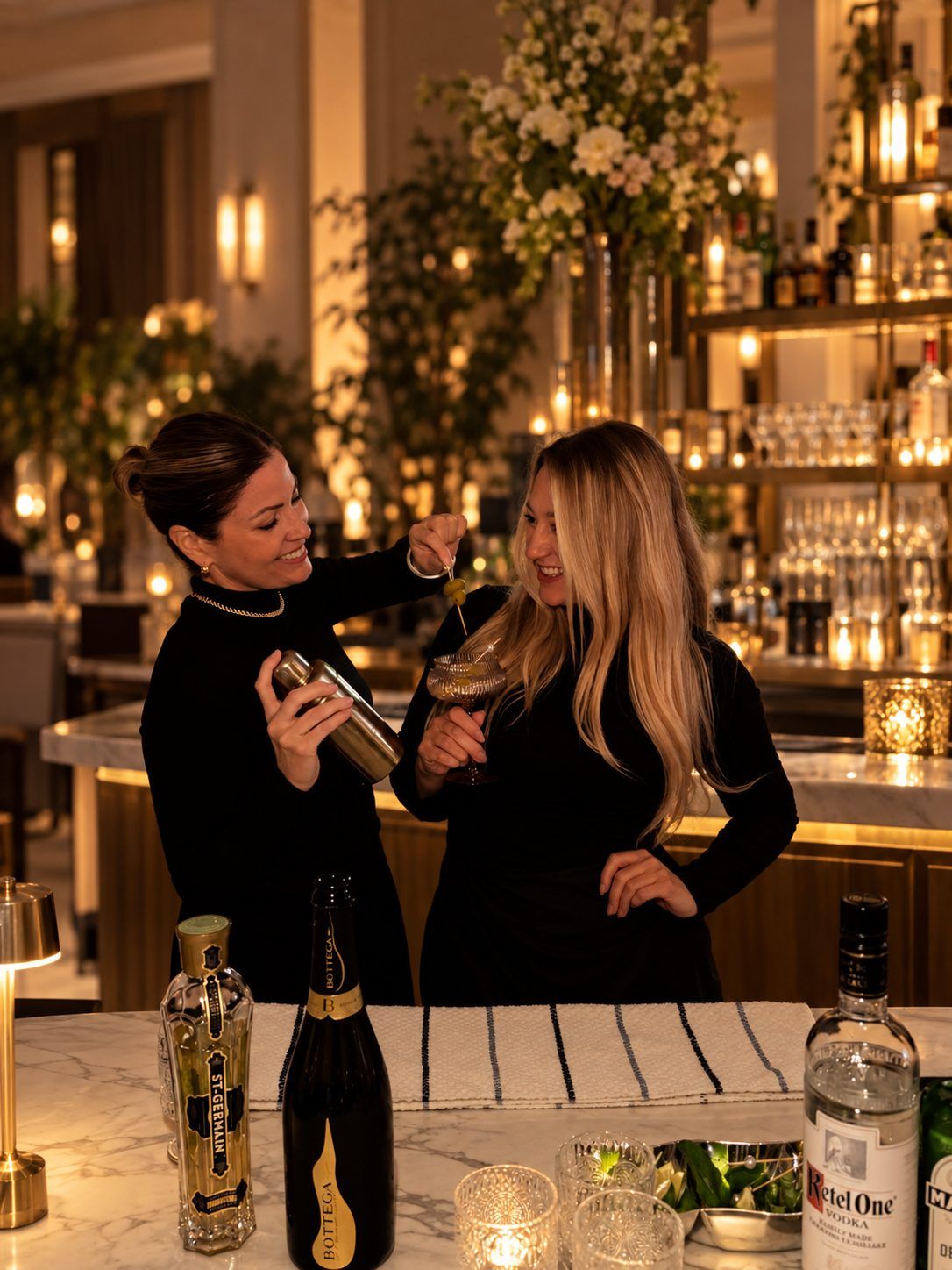 Two bartenders in black working a hotel bar