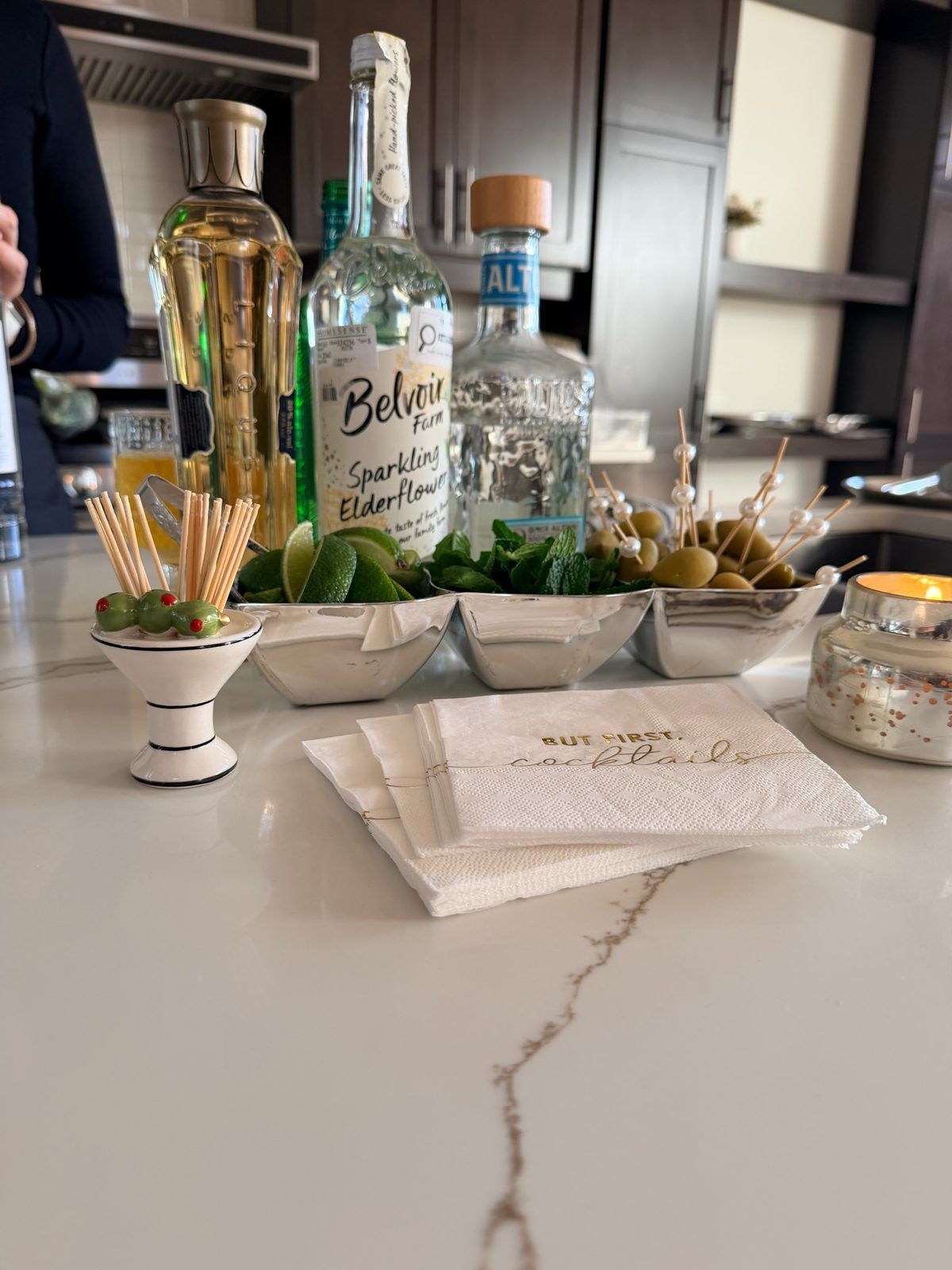 Fresh garnishes and bottles set out on a stone counter
