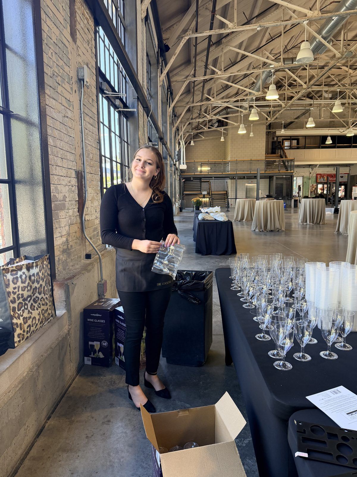A Cocktail Edit bartender setting up a glassware station in a converted warehouse venue